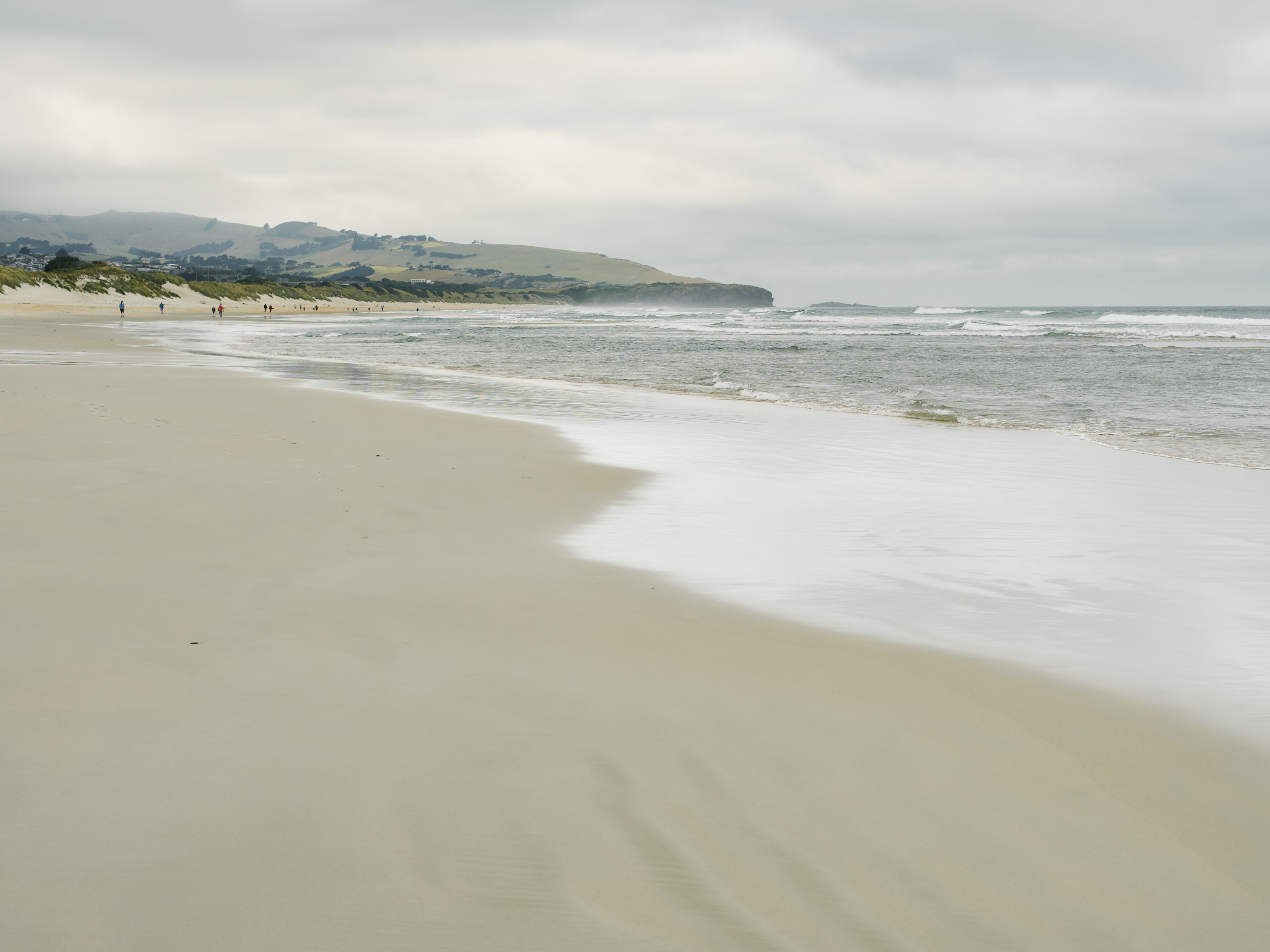 View of a beautiful sandy beach, the ocean waves gently crashing against the shore.